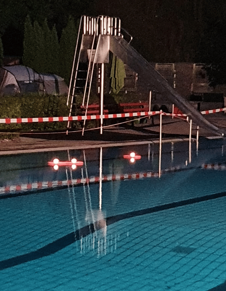 Abgesperrtes Schwimmbecken mit schwimmenden Lichtern